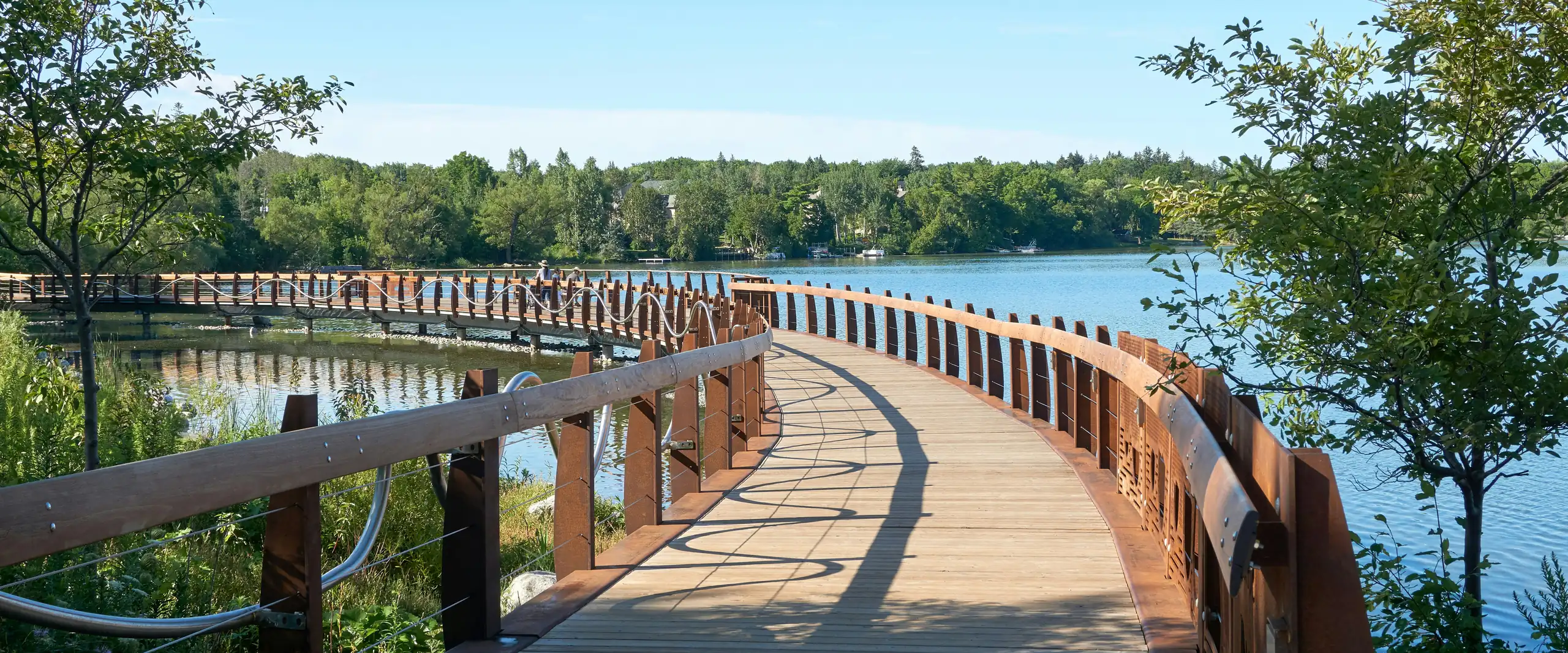 Curved wooden boardwalk over the water at Wilcox Lake in Richmond Hill