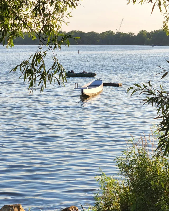 Boat on calm water framed by willow branches at Wilcox Lake in Richmond Hill